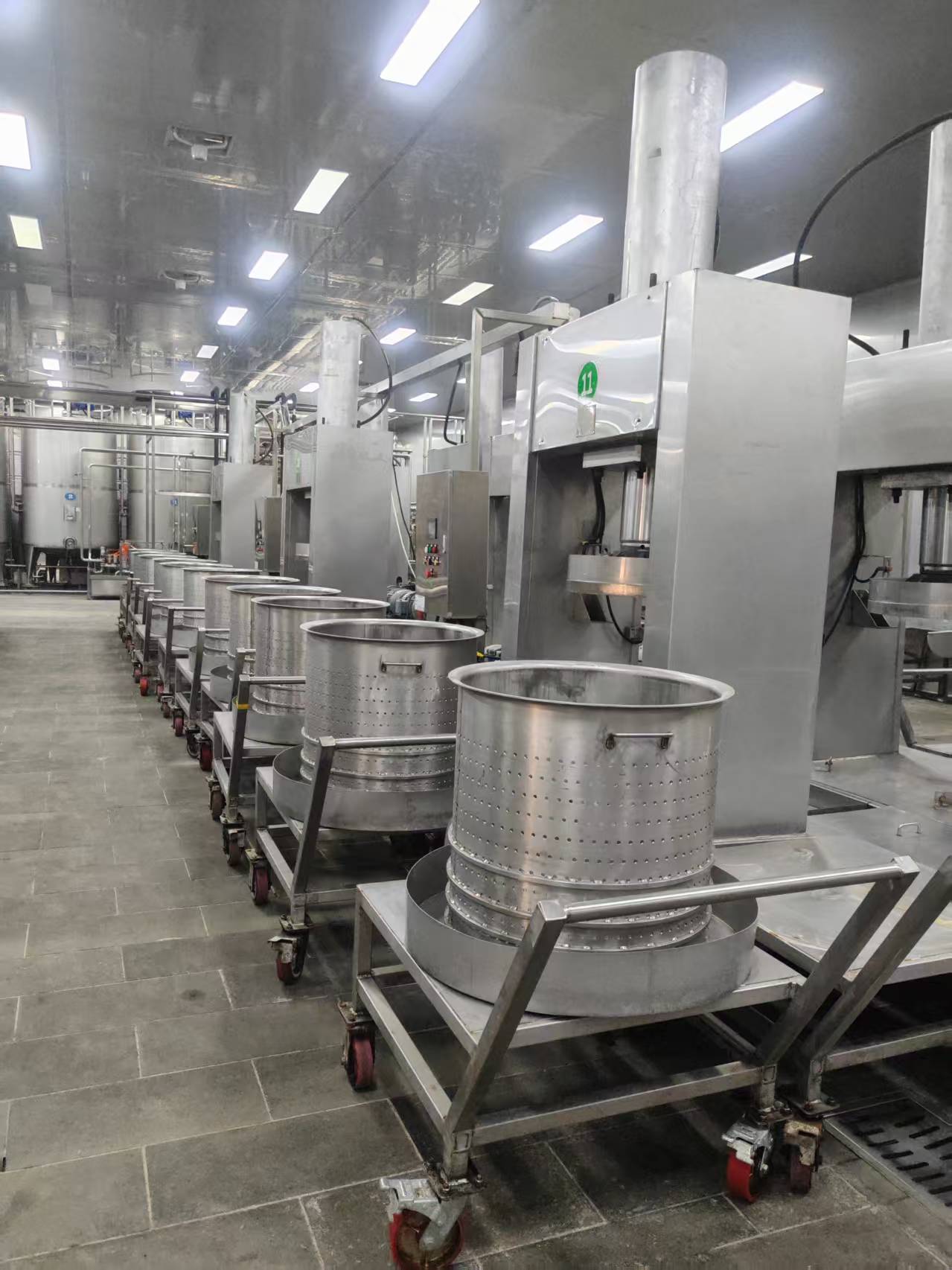 PT BERLIAN BERSINAR SEMESTA production floor with automated pressing equipment and stainless steel processing drums